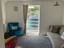 A living room with an armchair and sofa at Harbourside Retreat in Looe