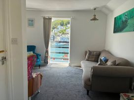 A living room with a sofa and armchair overlooking the harbor at Harbourside Retreat in Looe