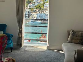 A living room with a window overlooking the water at Harbourside Retreat in Looe