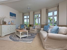 A living room with a sofa and armchair at 4 The Salcombe in Salcombe