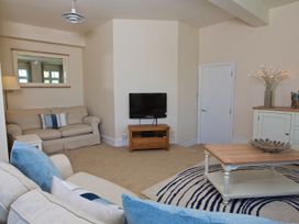 A living room with a sofa and television at 4 The Salcombe in Salcombe