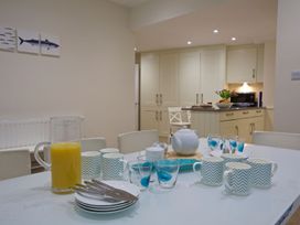 A kitchen with a dining table set up for breakfast at 4 The Salcombe in Salcombe