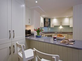 A kitchen with cabinets and countertop featuring bread and croissants at 4 The Salcombe, Salcombe