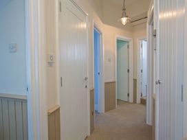 A hallway with multiple doors and a light fixture at 4 The Salcombe, Salcombe