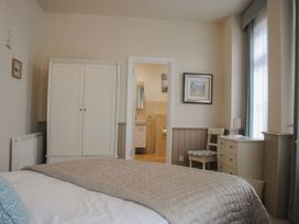 A bedroom with a bed and wardrobe leading to a bathroom at 4 The Salcombe Salcombe