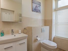 A bathroom with a sink, toilet, and a window at 4 The Salcombe in Salcombe