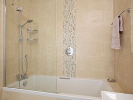A bathroom with a shower and bath tub at 4 The Salcombe in Salcombe