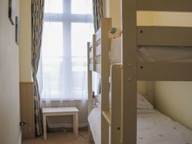 A bedroom with a bunk bed and a side table at 4 The Salcombe in Salcombe