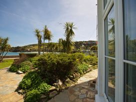 A garden with palm trees and a pathway at 4 The Salcombe in Salcombe
