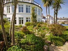 A garden with plants and a building in the background at 4 The Salcombe in Salcombe