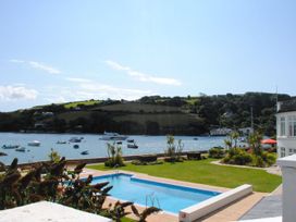 A pool with grass and boats by the water at 4 The Salcombe in Salcombe