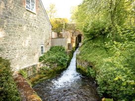 An outdoor area featuring a stone wall and a waterfall at French Mill in Shaftesbury