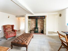 A living room with an armchair and a stove at French Mill in Shaftesbury