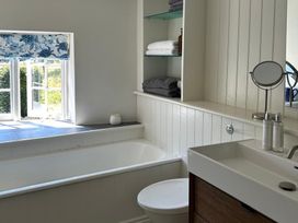 A bathroom with a bathtub, sink, and shelf at French Mill in Shaftesbury