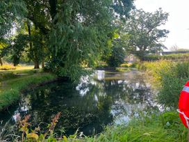 A pond surrounded by trees and grass at French Mill in Shaftesbury