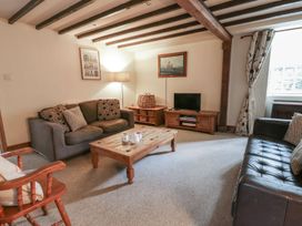 A living room with sofas, a coffee table, and a television at Dewi Villa Apartment in Aberaeron
