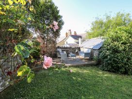 A garden with seating and flowers at Dewi Villa Apartment Aberaeron
