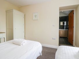 A bedroom with two beds and a bathroom door at Bramble near Cleator Moor