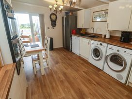A kitchen with appliances and a dining table at The Hideaway at Monterey in Helston