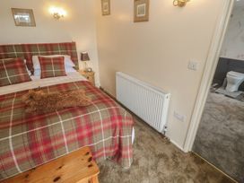 A bedroom with a bed and side table at The Hideaway at Monterey Helston