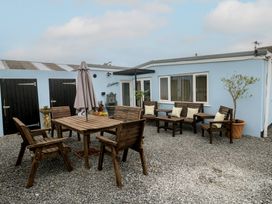 An outdoor seating area with wooden furniture at The Hideaway at Monterey in Helston