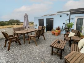 A garden with wooden furniture and planters at The Hideaway at Monterey Helston