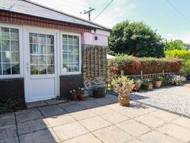 A garden with a stone wall and potted plants at The Jingle House in Tregony