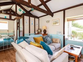 A living room with a sofa and bed at The Jingle House in Tregony
