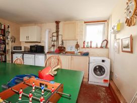 A kitchen with a washing machine and refrigerator at The Jingle House in Tregony