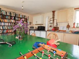 A kitchen with a bookshelf and foosball table at The Jingle House in Tregony