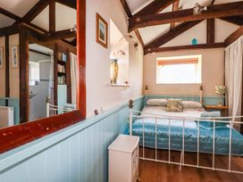 A bedroom with a bed and a nightstand at The Jingle House in Tregony