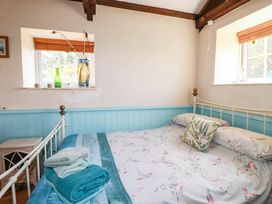A bedroom with a bed and towels on the side at The Jingle House in Tregony