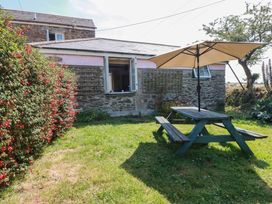 A garden with a picnic table and an umbrella at The Jingle House in Tregony