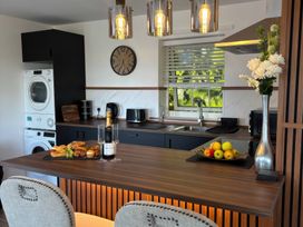 A kitchen with a washing machine, sink, and fruit platter at Truly Scrumptious in Yarm
