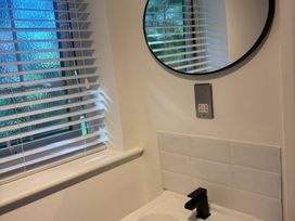 A sink with a mirror and window in the bathroom at Truly Scrumptious Yarm