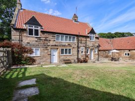 A house with benches and tables in the garden at Farmhouse in Whitby
