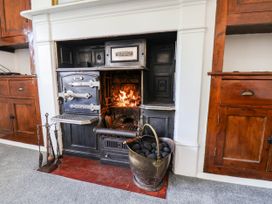 A kitchen with a stove and fireplace at the Farmhouse in Whitby