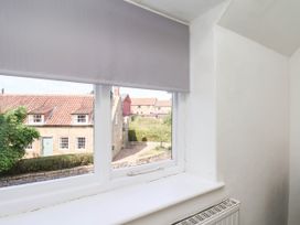 A window with a view of houses and garden at the Farmhouse in Whitby