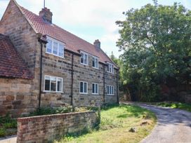 A stone house with windows and a driveway at Farmhouse in Whitby