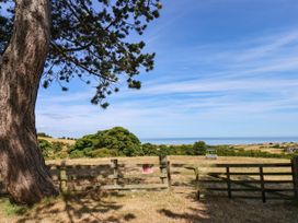 A view of a tree and ocean from a field at Farmhouse in Whitby