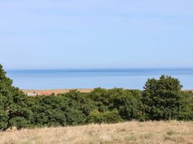 A view of the ocean and trees from a grassy area at Farmhouse in Whitby