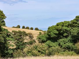 A view of trees and hills with ocean in the distance at Farmhouse Whitby