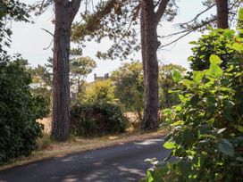 A view of trees and bushes along a road with a building in the background at Farmhouse Whitby