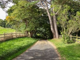 A pathway surrounded by trees and a fence at Ewe Cote Hall Farmhouse in Whitby