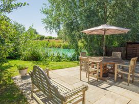A garden with a seating area and a view of water at Oak Lodge