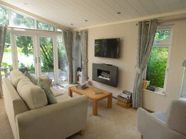A living room with a television and fireplace at Oak Lodge
