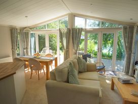 A living room with a sofa and dining table at Oak Lodge