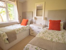 A bedroom with two beds and a nightstand at Oak Lodge