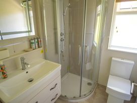 A bathroom with a shower, sink, and toilet at Oak Lodge