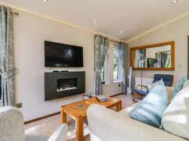 A living room with a television and fireplace at Oak Lodge Battisford near Stowmarket
